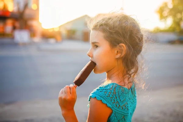 Menina criança comer sorvete fora de uma vista lateral — Fotografia de Stock