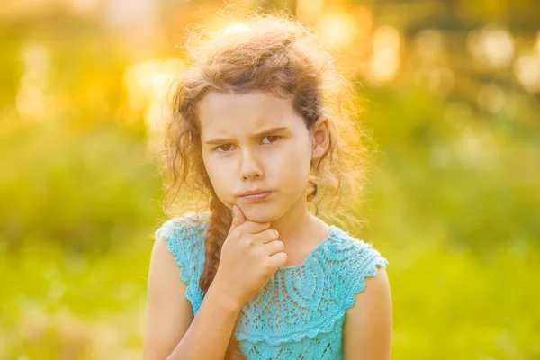 Teenage girl is thinking on a green background on the nature of — Stock Photo, Image