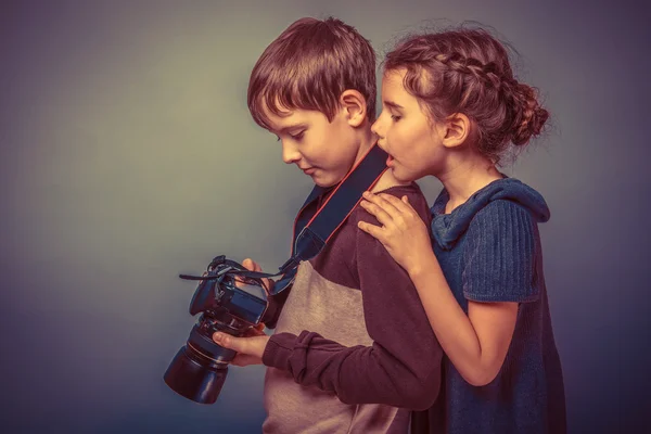 Dospívající chlapec s dívkou sledovat snímky ve fotoaparátu na skupi — Stock fotografie