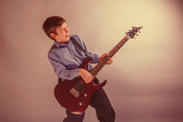 Teenager boy brown hair European appearance playing guitar, laug — Stock Photo, Image