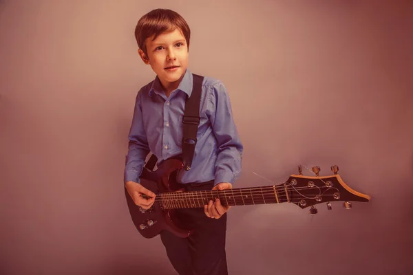 Adolescente chico marrón pelo de europeo apariencia jugando guitarra ex — Foto de Stock