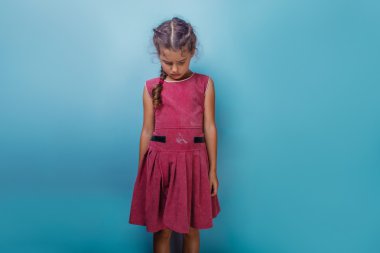 Girl European appearance decade  angry frowns on blue  backgroun