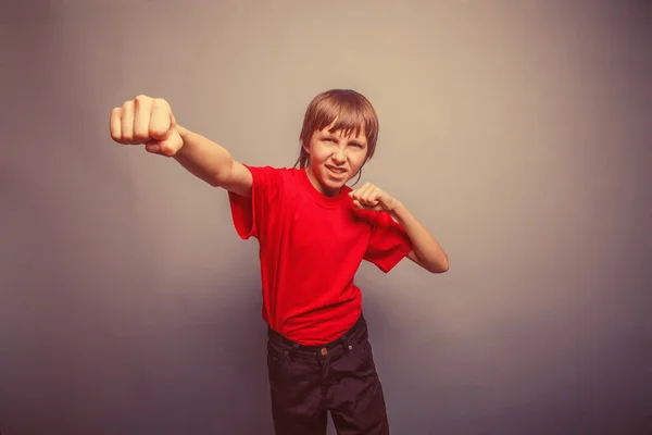 Boy, teenager, twelve his years  red  in shirt, red showing  fis — Stock Photo, Image