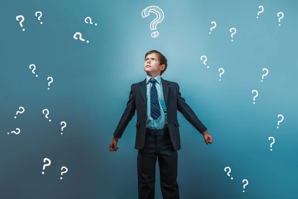 A boy of twelve European appearance in a suit holding a blank sh — Stock Photo, Image