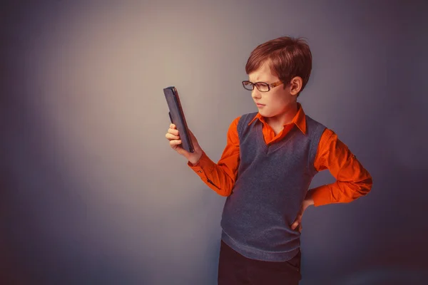 European-looking boy of  ten years in glasses  looks at the plat — Stock Photo, Image