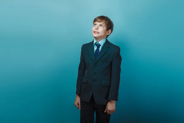 A boy of twelve European appearance in a suit looks up smiling o — Zdjęcie stockowe