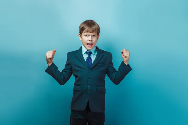 A boy of twelve European appearance in a suit shouting angry  on — Stock Photo, Image