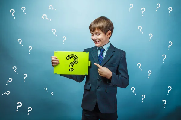 A boy of twelve European appearance in a suit holding a blank sh — Stock Photo, Image