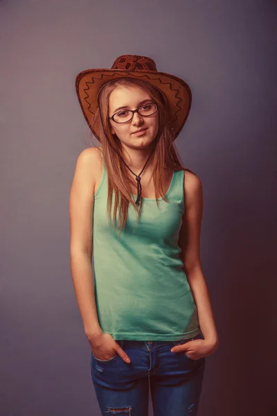 एक ग्रीन टी-शर्ट में नीली जीन्स में महिला टोपी के साथ — स्टॉक फ़ोटो, इमेज