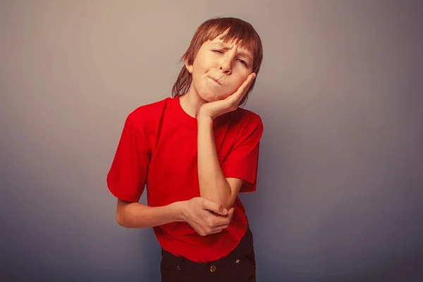 Boy teenager European appearance in a red shirt a hand to his ch — Stock Photo, Image