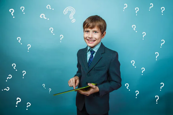 A boy of twelve European appearance in a suit holding a blank sh — Stock Photo, Image