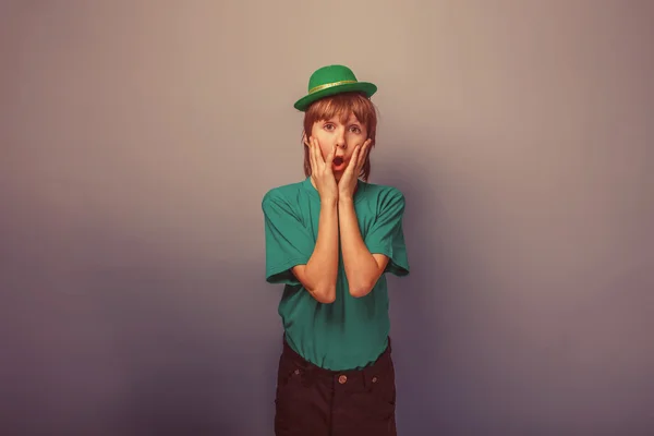 European appearance teenager boy in T-shirt with green hat put h — Stock Photo, Image