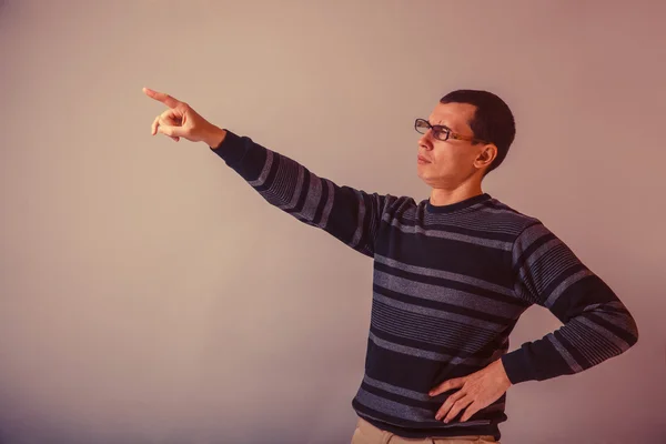 European-looking man of 30 years with glasses shows a finger in — Stock Photo, Image