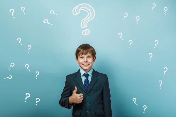 A boy of twelve European appearance in a suit holding a blank sh — Stock Photo, Image