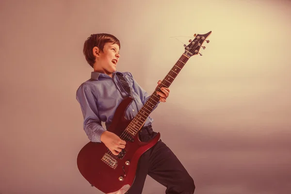 Teenager junge braune Haare europäisches Aussehen spielen Gitarre, happ — Stockfoto