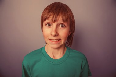 On yaşında çocuk Avrupa görünümlü bir gri backg sürpriz gülümseme