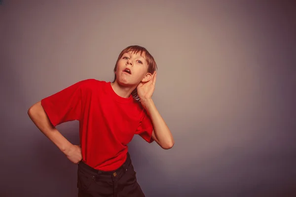Evropská vzhled chlapec zaslechne deset let, úroky, ucho na gra — Stock fotografie