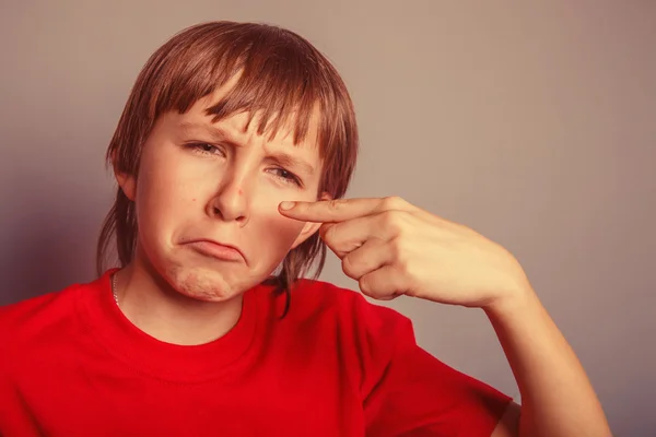 Rapaz de aparência europeia de dez anos borbulha no nariz, chateado — Fotografia de Stock