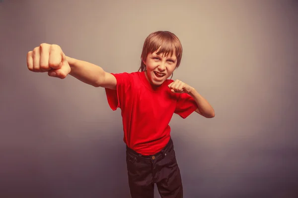 European-looking boy of ten years shows a fist, anger, danger, m — Stock Photo, Image