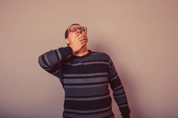 Male European appearance brunet in sweater yawns covers her mout — Stock Photo, Image