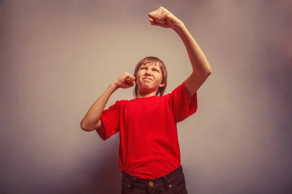 Boy, teenager, twelve years  red  in shirt,  showing  fists his — Stock Photo, Image