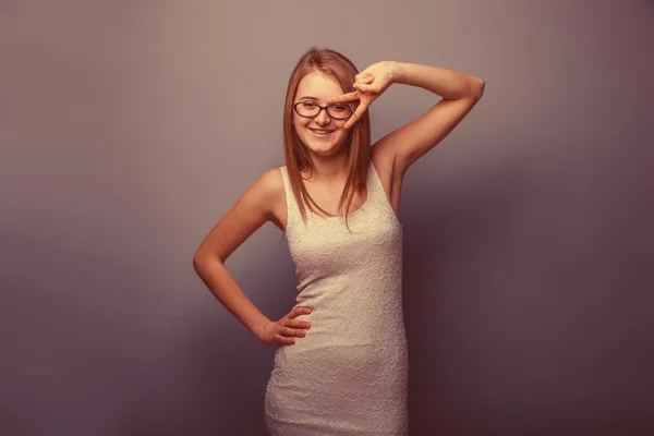 Europejskiej szuka dziewczyny dwadzieścia lat w okularach pokazano dwa fin — Zdjęcie stockowe