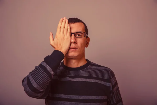 Europese uitziende man van 30 jaar met een bril, stak zijn hand over — Stockfoto