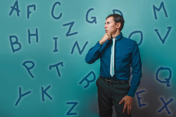 Man male teacher businessman thinks alphabet letters looking awa — Stockfoto