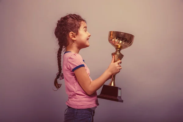 Niña de 6 años de apariencia europea sostiene una taza en su han — Foto de Stock