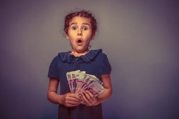 Teen girl of European appearance holds five denominations of mon — Stock Photo, Image