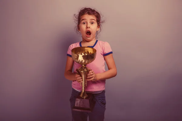 Mädchen 6 Jahre europäisches Aussehen hält einen Pokal in der Hand — Stockfoto