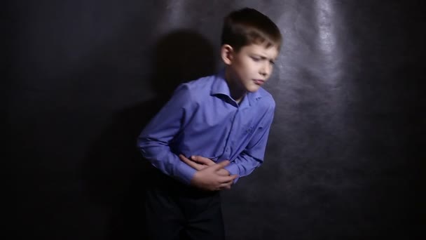 Menino adolescente dor de estômago diarréia em uma camisa azul, estúdio de fundo vídeo — Vídeo de Stock