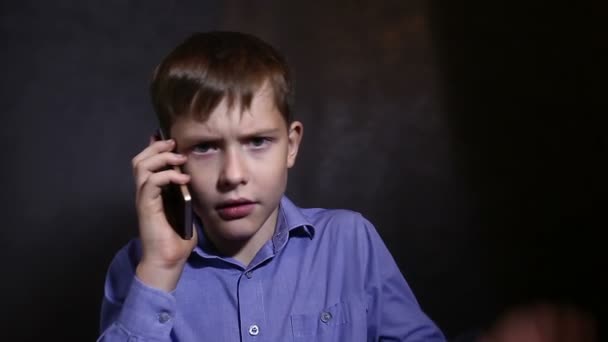 Adolescente chico hablando por teléfono emoción estudio fondo en azul camisa vídeo — Vídeo de stock