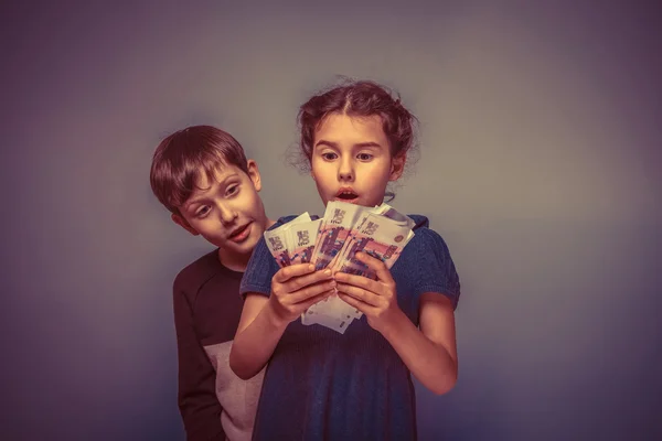 Girl holding money bills in the hands of the boy opened his mout — Stock Photo, Image