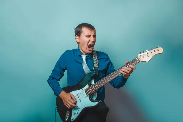 Un uomo dall'aspetto europeo trent'anni di chitarra su — Foto Stock