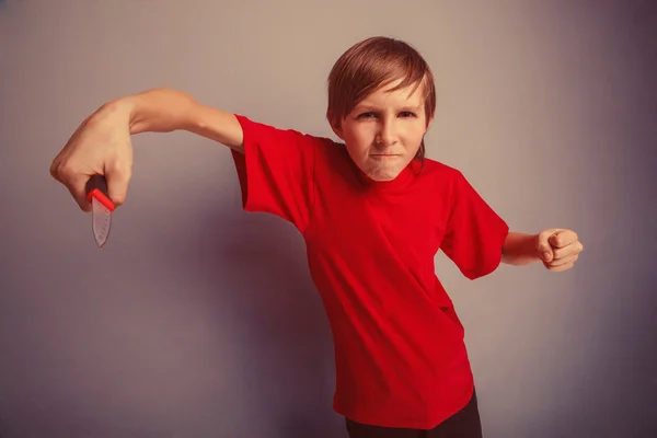 Teenager boy twelve years in the red t-shirt with a knife evil B — Stock Photo, Image