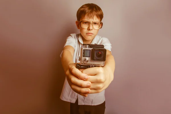 Un ragazzo di 10 anni di apparenza europea con gli occhiali che tengono un — Foto Stock