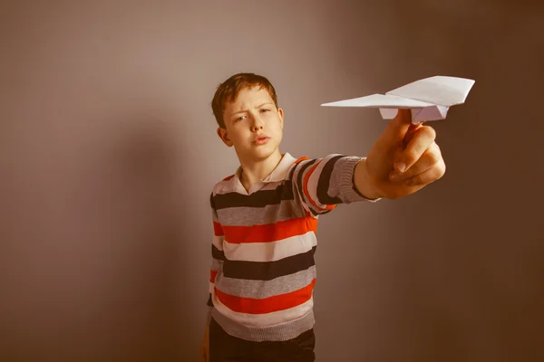 Boy teenager European appearance Brown launches a paper airplane — Stock Photo, Image