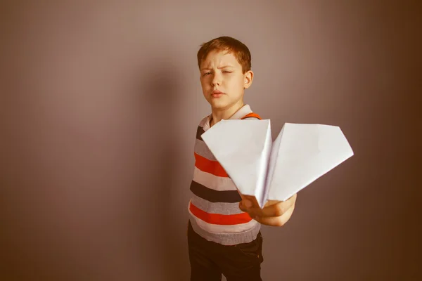 Boy teenager European appearance Brown launches a paper airplane — Stock Photo, Image