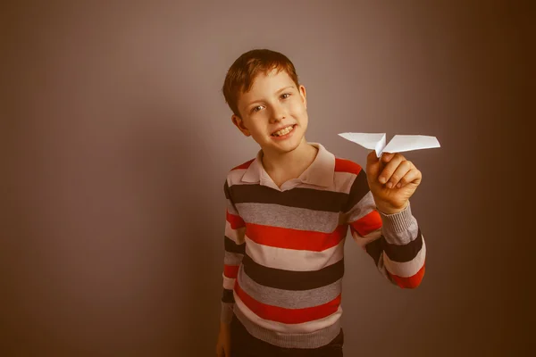 Chico adolescente europeo apariencia marrón lanza un avión de papel —  Fotos de Stock