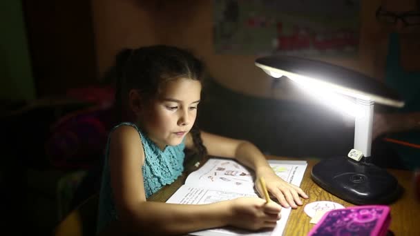 Tiener in de avond doen meisje huiswerk lessen trekt licht van de lamp — Stockvideo