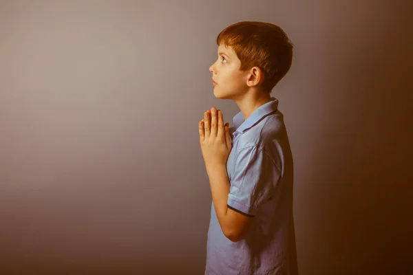 Boy teenager European appearance in a blue shirt brown praying l — Stock Photo, Image