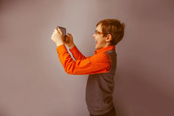 Europeiska-ser pojke på tio år i glas håller tablet jag — Stockfoto