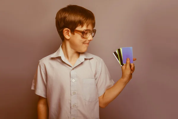 Um menino de 10 anos de aparência europeia com óculos segurando kr — Fotografia de Stock