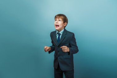 a  boy of twelve  European appearance in a suit shouting angry o
