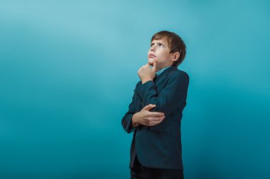 a  boy of twelve European appearance  in a suit looking up frown