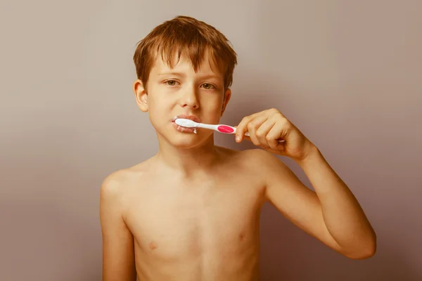 Um menino de 10 anos de aparência europeia nu torso escovação h — Fotografia de Stock