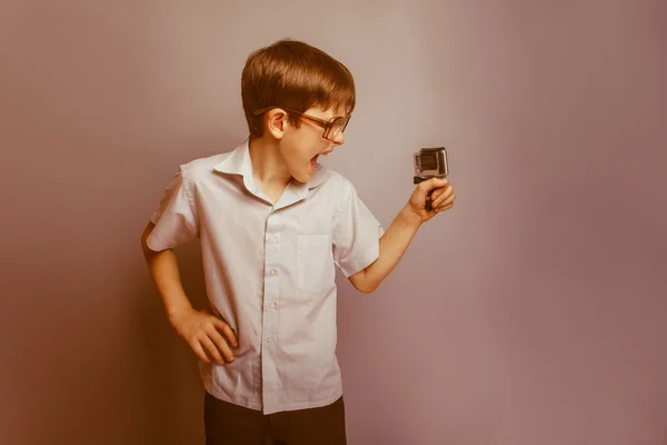 Een jongen van 10 jaar van Europees uiterlijk met glazen houden een — Stockfoto