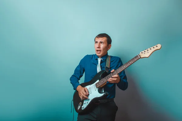 A  man of European  appearance thirty years of playing guitar on — Stock Photo, Image