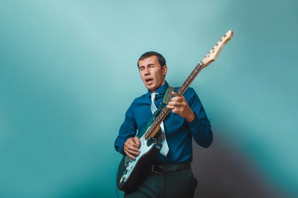A  man of European appearance thirty years of playing guitar on — Stock Photo, Image